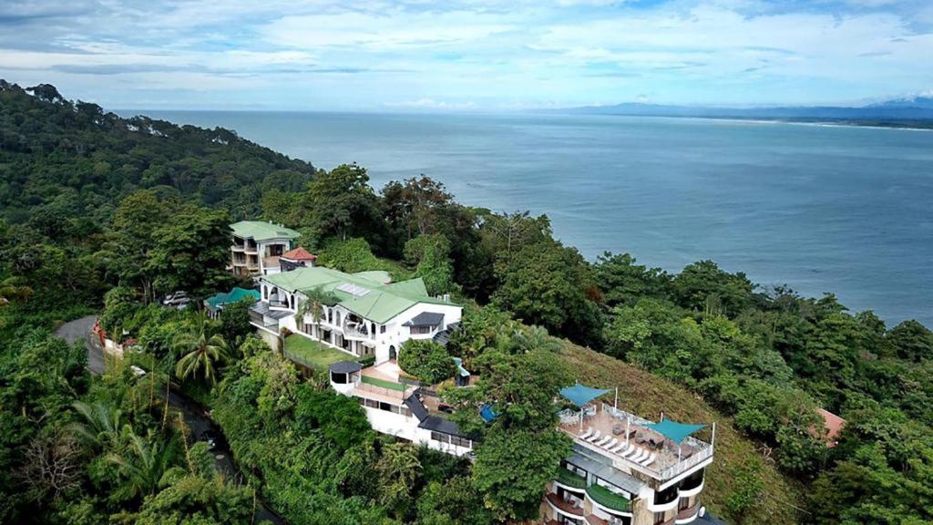 z góry widok na dom na wzgórzu nad wodą w obiekcie Oceans Two Resort w mieście Manuel Antonio
