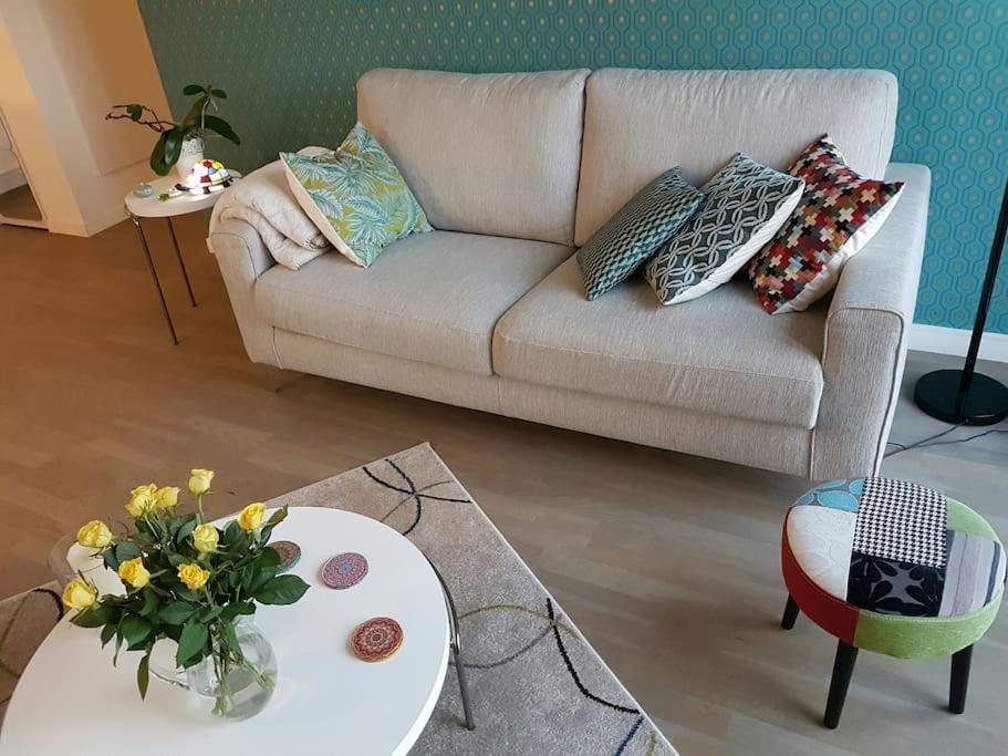 a living room with a couch and a table with flowers at AppartCosy 50 m2 (avec garage) in Bordeaux