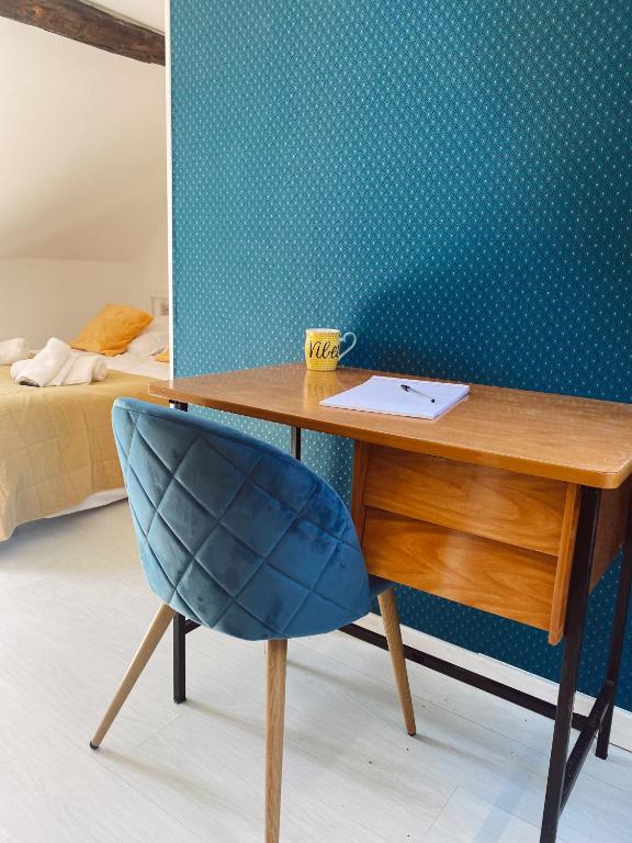 - un bureau avec une chaise bleue à côté d'une chambre dans l'établissement Maison cosy avec 3 chambres et 3 salles de bains, à Amiens