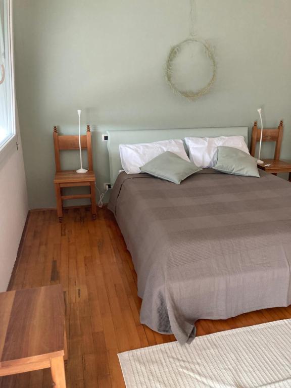 een slaapkamer met een groot bed en een houten vloer bij Casa di kikka in Bassano del Grappa