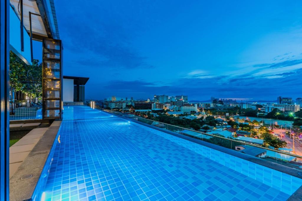 a swimming pool on the roof of a building at night at T Pattaya Hotel by PCL in Pattaya Central