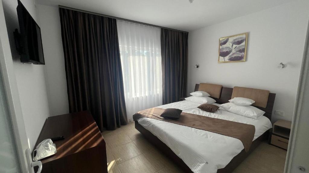 Una habitación de hotel con dos camas y un televisor. en David INN, en Băile Felix