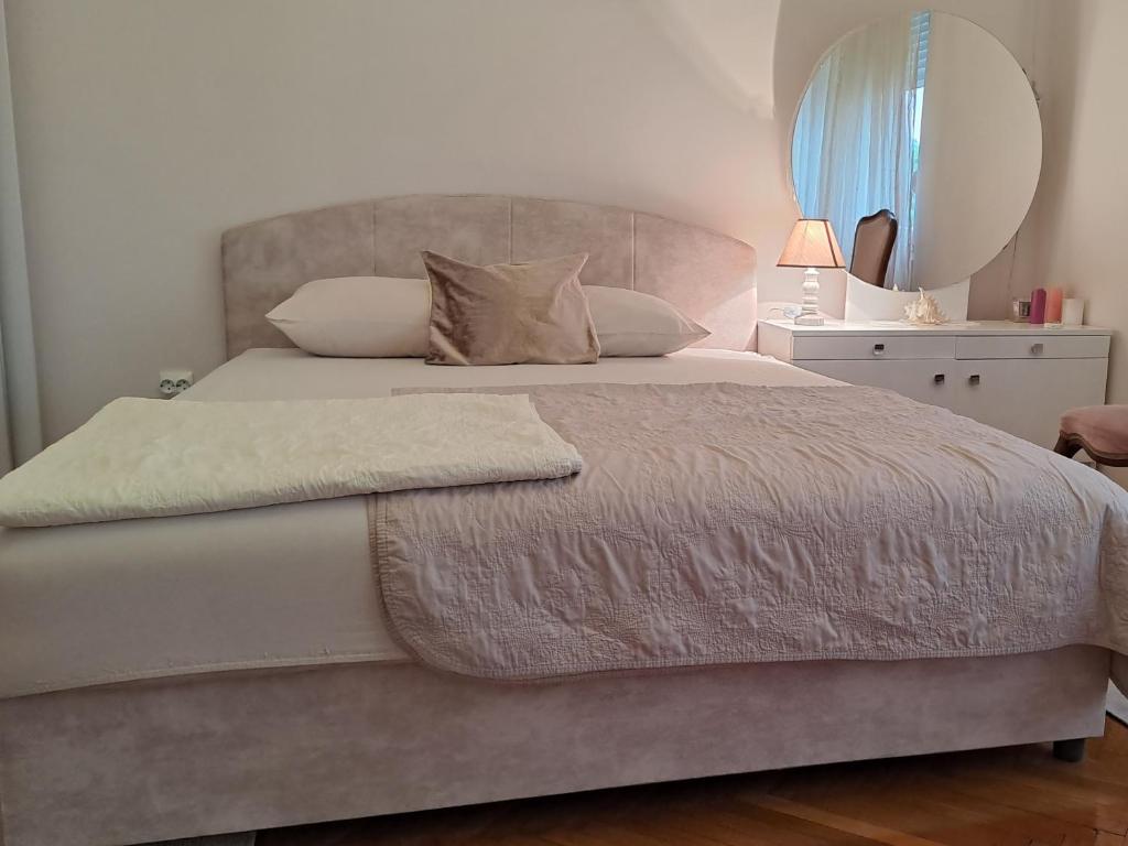a bedroom with a large bed with a mirror at Guest House Topla in Herceg-Novi