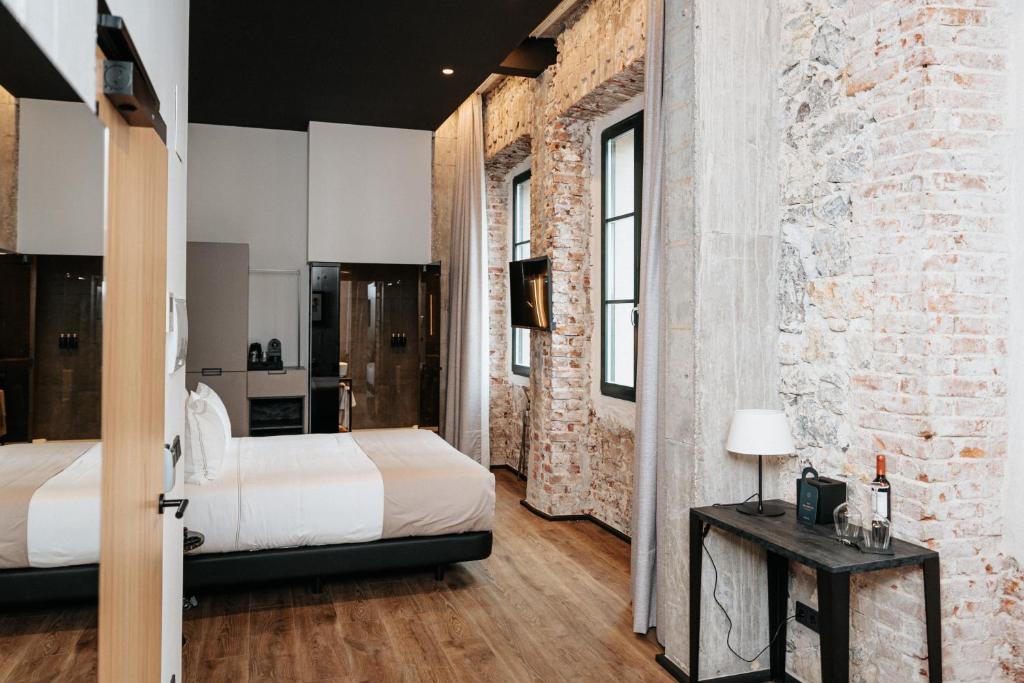 um quarto com 2 camas e uma parede de tijolos em Hotel Luruna Palacio Larrinaga em Mundaka