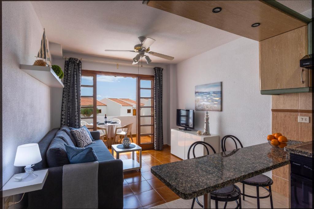 cocina y sala de estar con sofá y mesa en Garden City Private Apartment Costa Adeje en Playa Fañabe