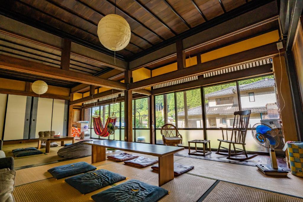 a living room with a table and some chairs at 恐竜博物館より車で15分 -1組様限定の築140年の古民家農家民宿 "晴れのちもっと晴れ" 里山集落で超田舎滞在- 昔懐かしい五右衛門風呂とにわとり卵の収穫体験付き 