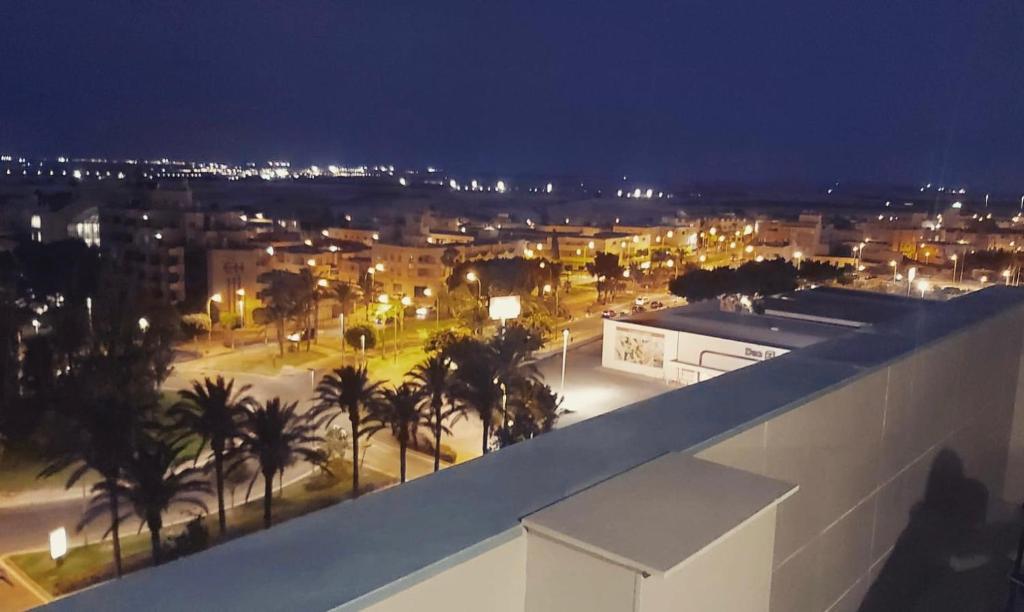 a view of a city at night with palm trees at Apartamento Torre Laguna in El Ejido