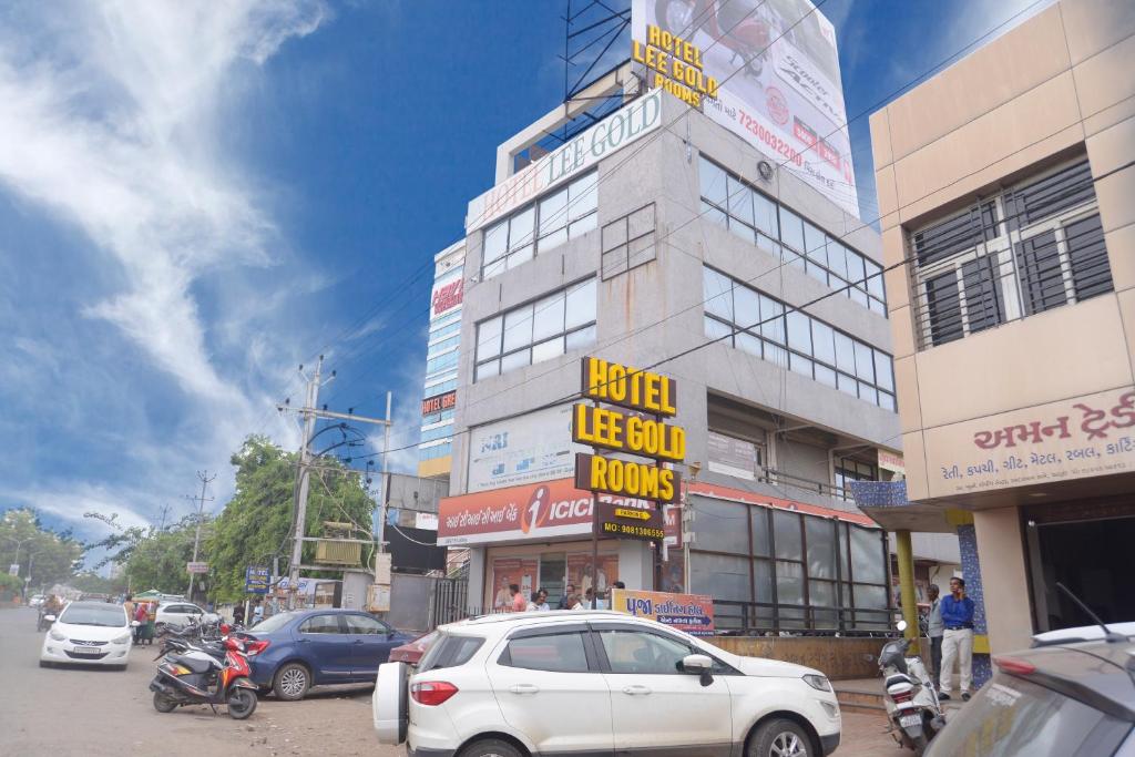 een straat met auto's geparkeerd voor een gebouw bij HOTEL LEE GOLD in Anand