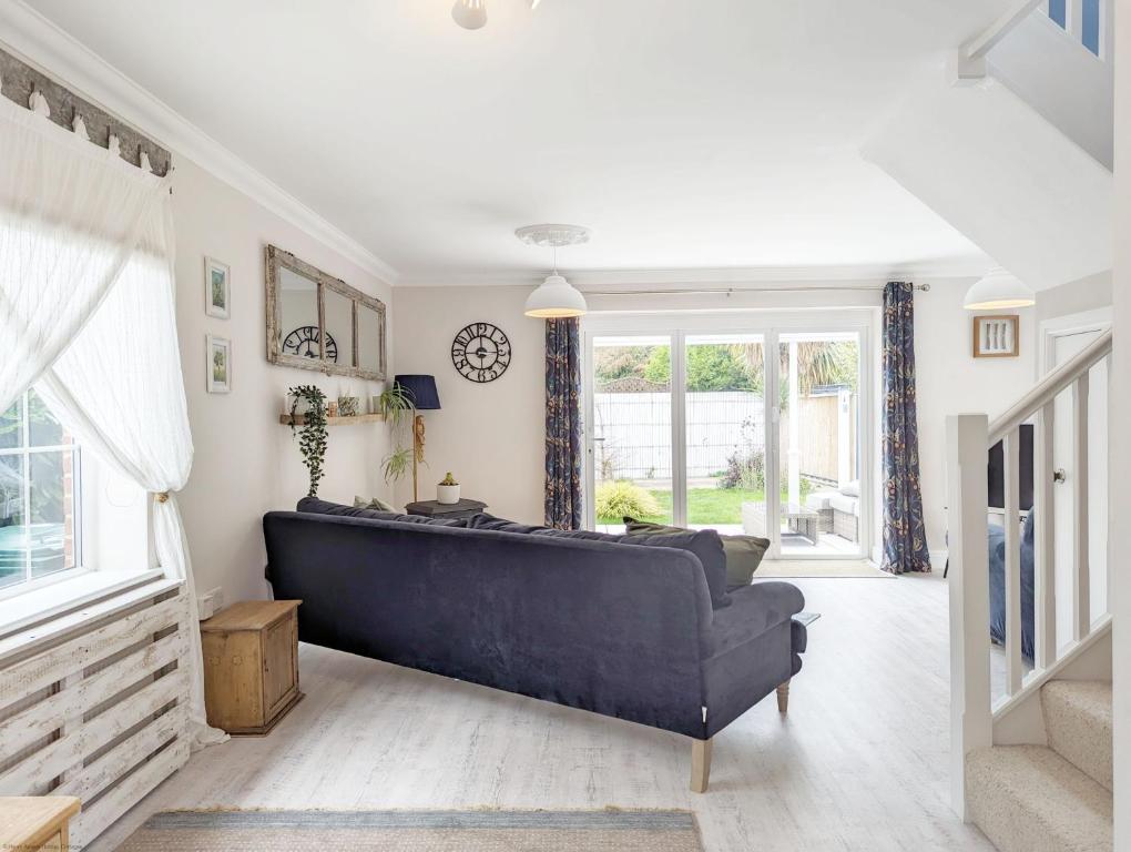 a living room with a blue couch and a window at Sweetpea Cottage in Hambrook