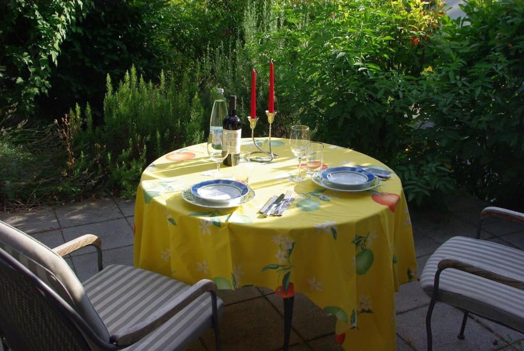 a table with a yellow table cloth and wine glasses at Ruhe genießen und wohlfühlen auf 70m² in Ober-Laudenbach