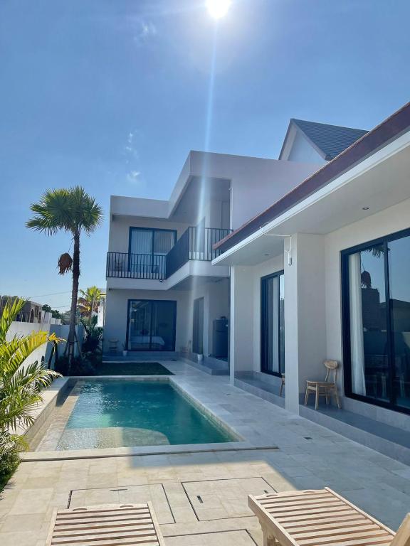 a villa with a swimming pool and a house at Mega Canggu Guest House in Canggu
