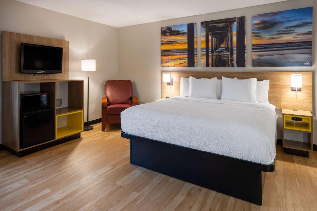 a hotel room with a bed and a flat screen tv at Days Inn by Wyndham Pleasant Prairie Kenosha in Kenosha