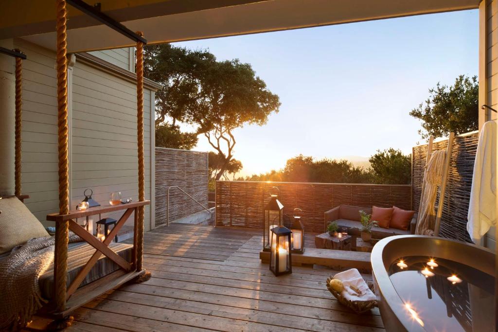 Una terraza de madera con un sofá y una mesa. en Carmel Valley Ranch, in The Unbound Collection by Hyatt, en Carmel Valley