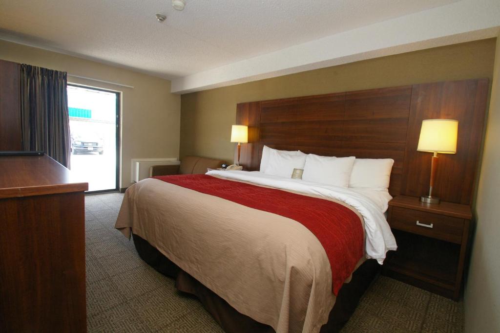 a hotel room with a large bed and a window at Comfort Inn in Huntsville