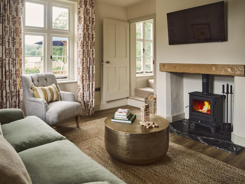 a living room with a couch and a fireplace at Bridge House at Woodhall Estate in Hertford
