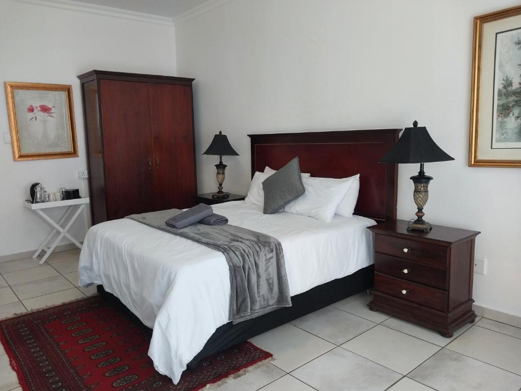 a bedroom with a large bed with a wooden headboard at The Goldstone in Pretoria