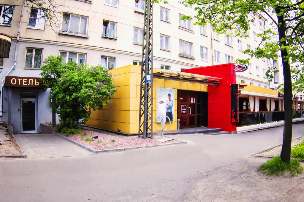 a building on a city street with a man in the window at Tourist Inn in Petrozavodsk