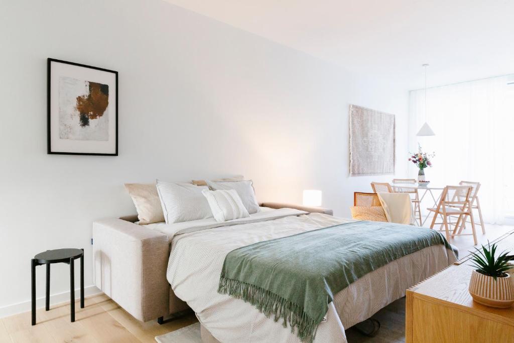 Un dormitorio blanco con una cama grande y una mesa en High-end flats at South area, en Amberes