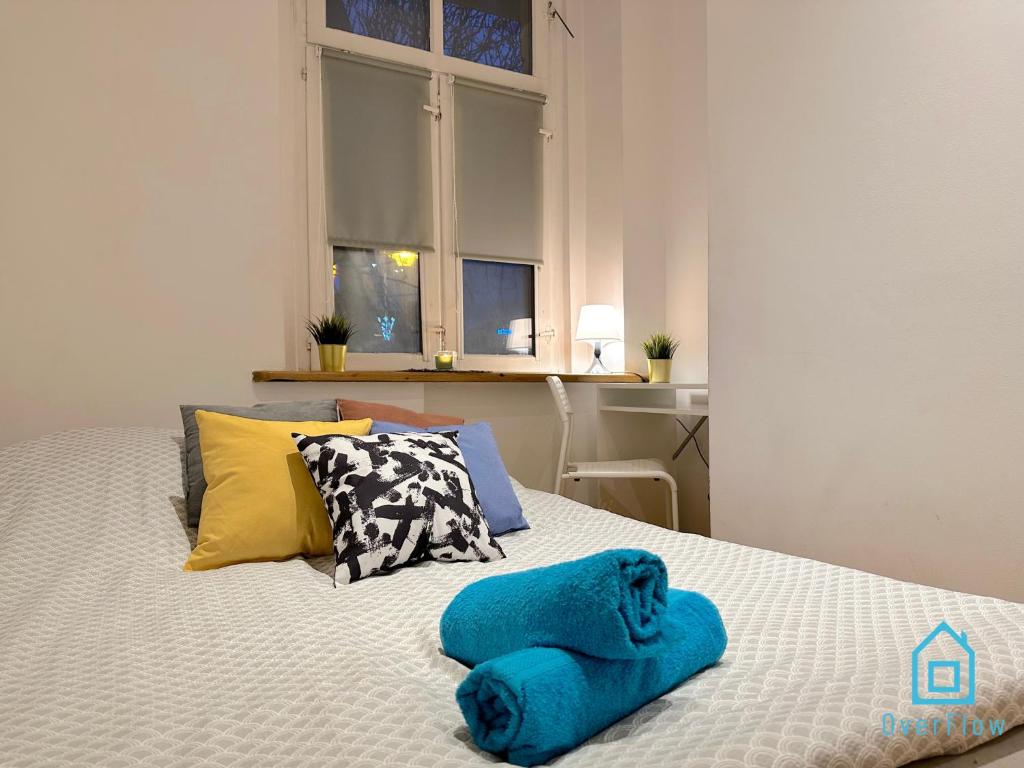 a bedroom with a bed with blue towels on it at Square Room in Gdańsk