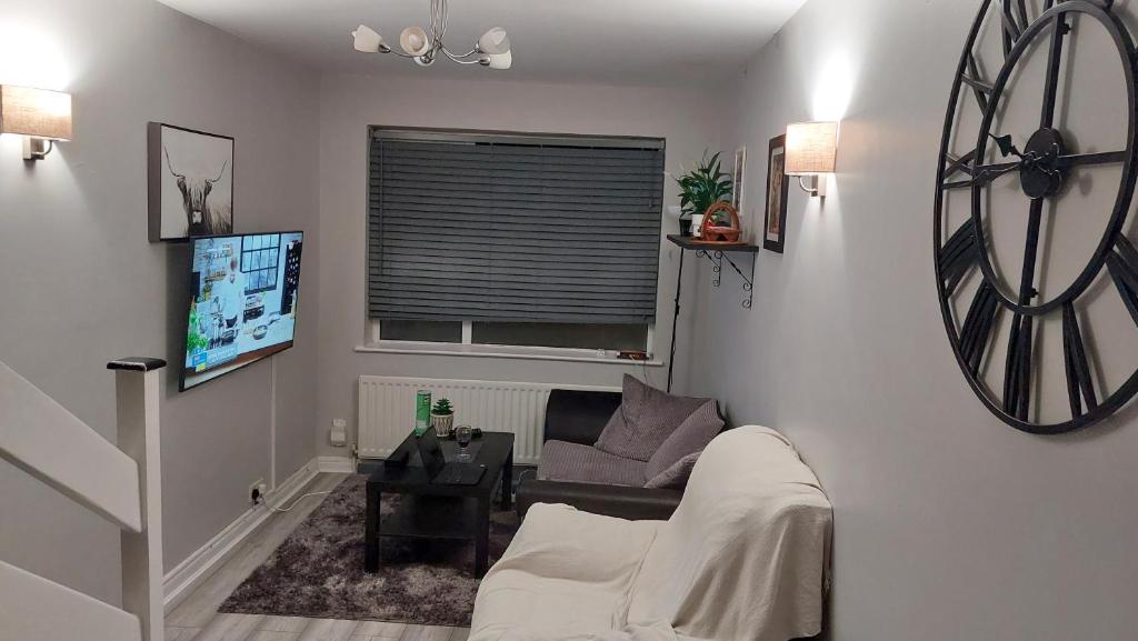 a living room with a couch and a clock on the wall at My Little Home in Letterkenny