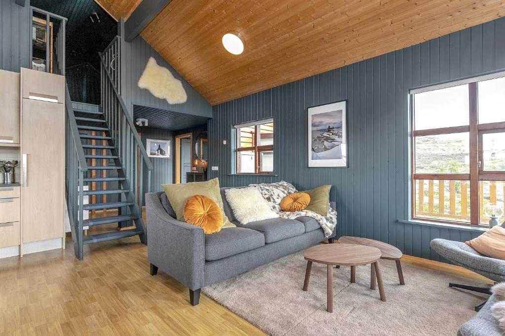 a living room with a gray couch and a staircase at The Angels House in Selfoss