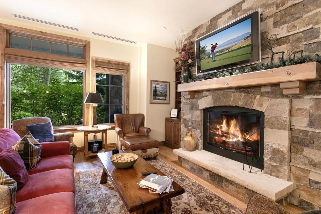a living room with a fireplace with a tv above it at B107 Beaver Creek Landing condo in Beaver Creek