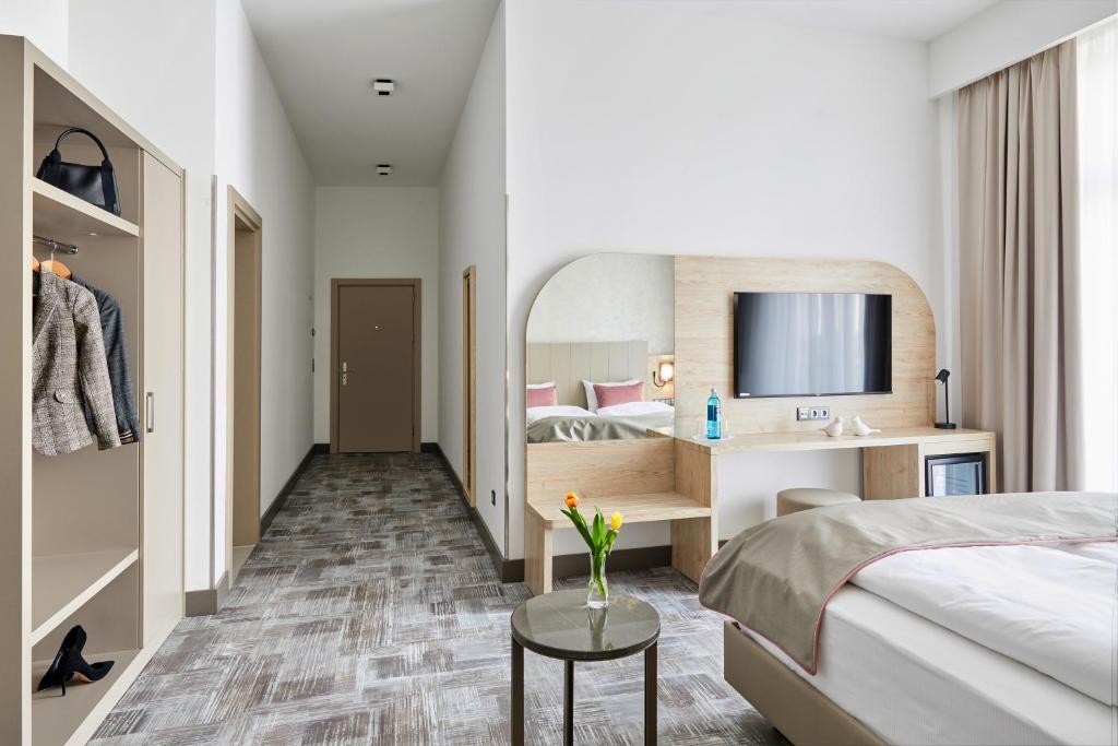 a hotel room with a bed and a desk at Hotel KAISERHOF in Bitterfeld