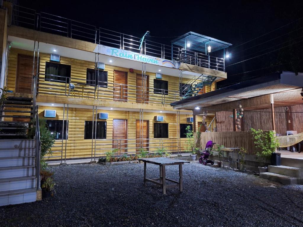 a building with a table in front of it at night at Rain Haven Lodging House in Coron