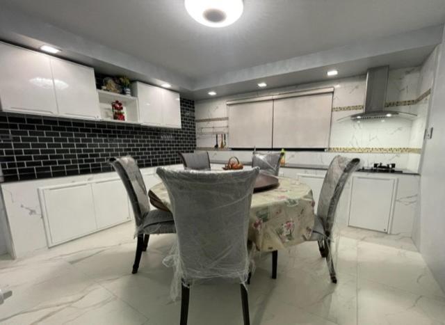 uma cozinha com mesa e cadeiras num quarto em บ้านนายหัว ก ชุมพร em Ban Tha Samet (1)