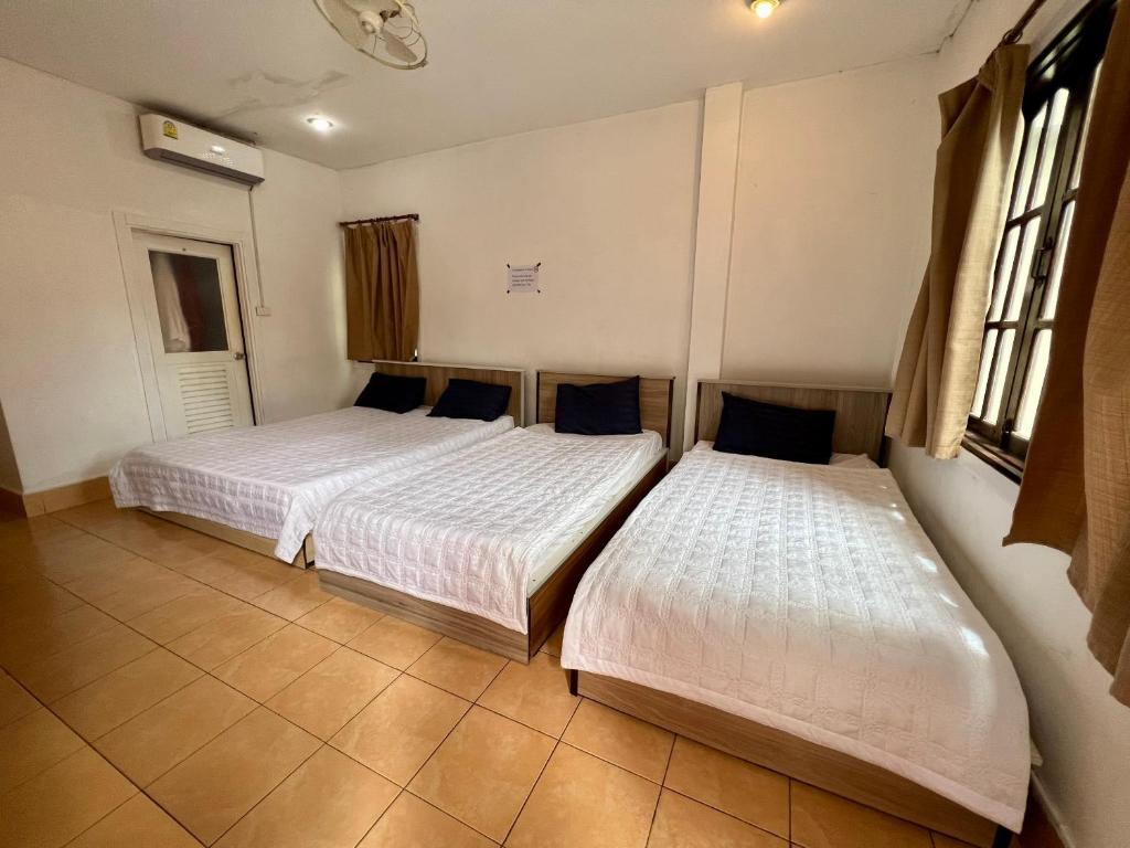 twee bedden in een kamer met twee ramen bij Vientiane Star Hotel in Vientiane
