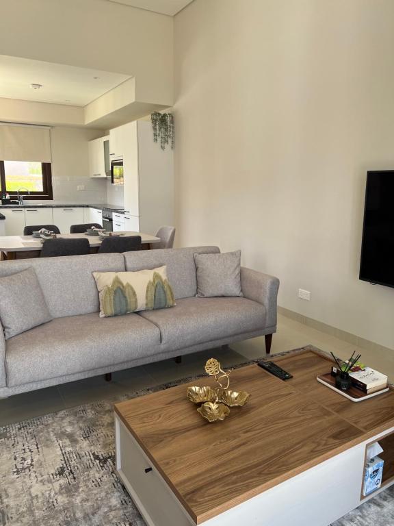 a living room with a couch and a coffee table at Escape Villa in As Sīfah