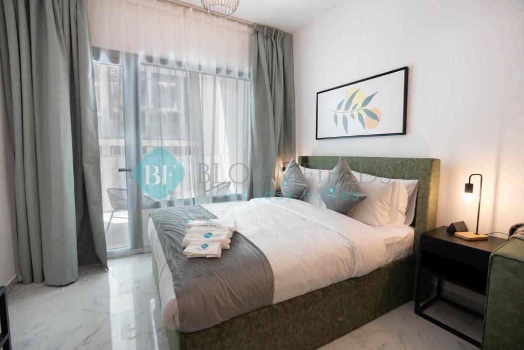 a bedroom with a large bed and a large window at Executive Studio In Oasis in Abu Dhabi