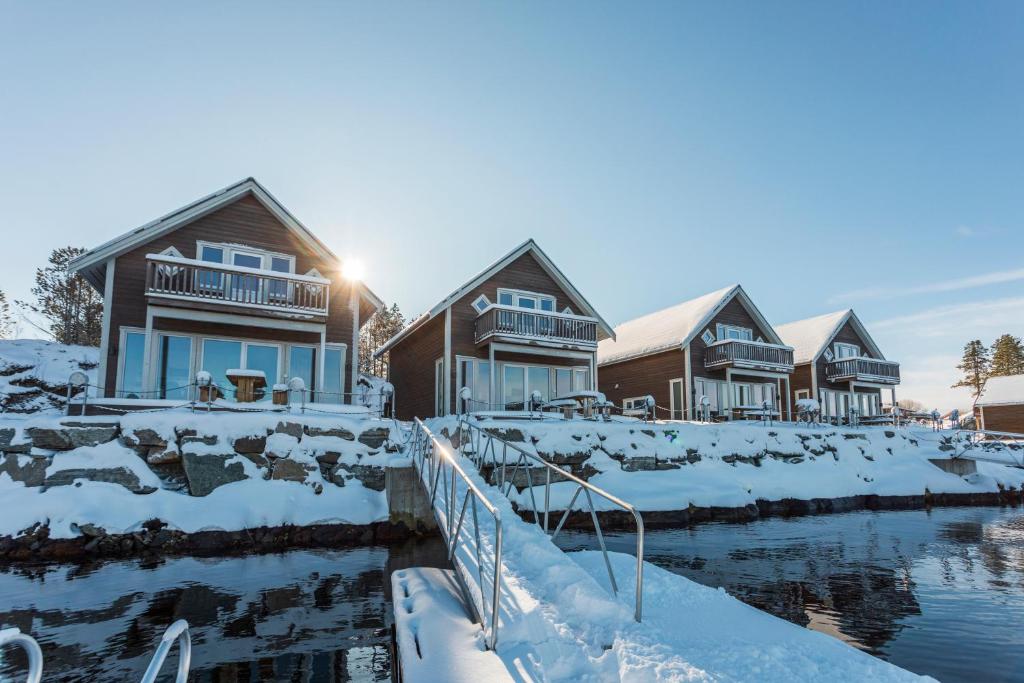 una fila de casas cubiertas de nieve en Nærøysund Rorbuer AS, en Rørvik