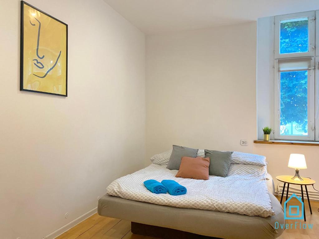 een slaapkamer met een bed met blauwe slippers erop bij Twig Room in Gdańsk