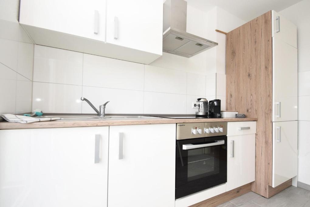 a white kitchen with a sink and a stove at Air Apartments 5 in Bremen