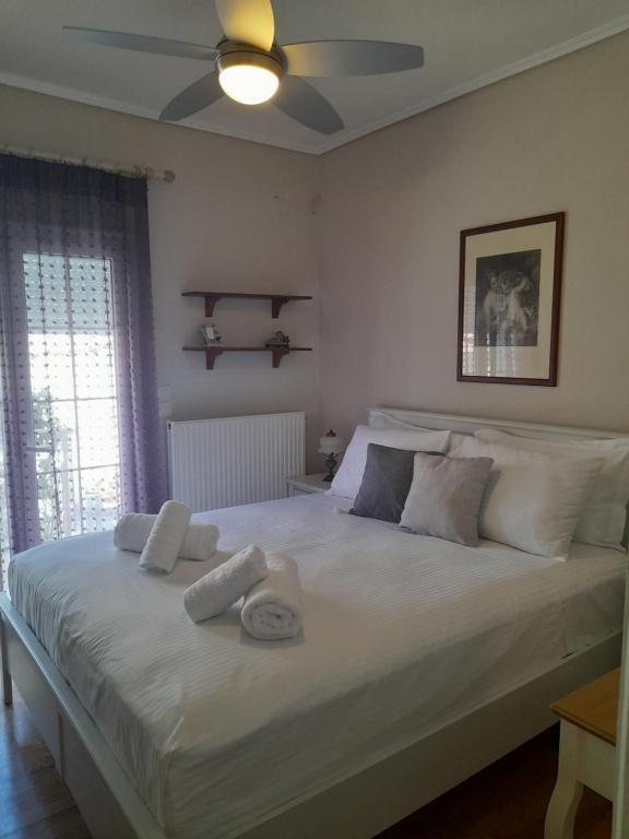 sypialnia z dużym białym łóżkiem z ręcznikami w obiekcie Lydia House w mieście Korynt
