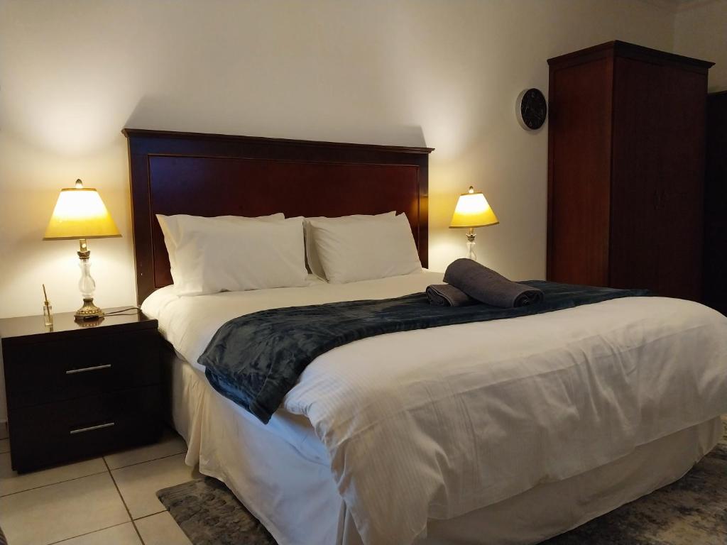 a bedroom with a large bed with two lamps at The Diamond in Pretoria
