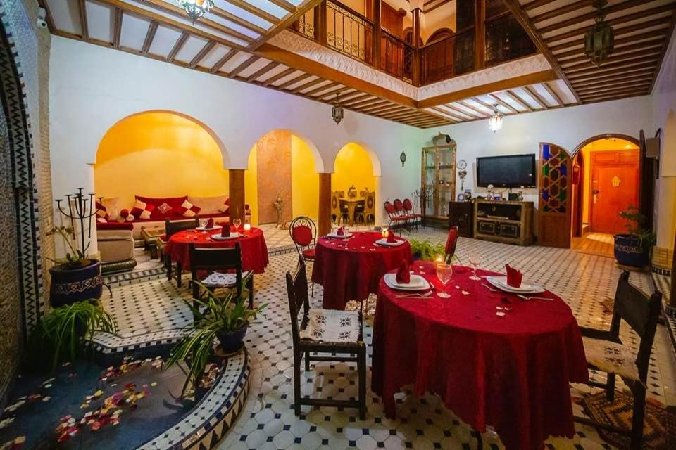 uma grande sala com mesas vermelhas e cadeiras em Suite La lune de Marrakech em Marrakech