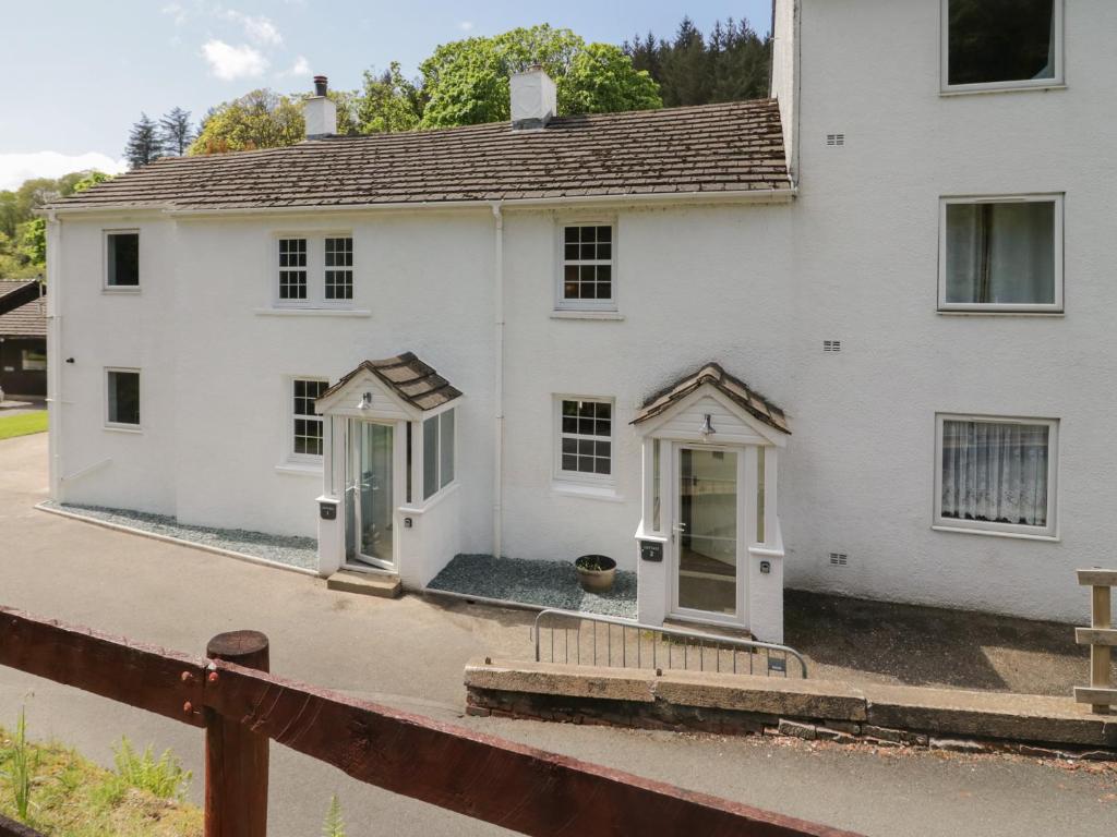 a white house with two doors and a porch at Garden Cottage No 2 in Keswick
