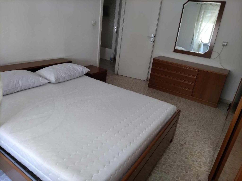 um quarto com uma cama com um espelho e uma cómoda em Casa Maria em Terracina
