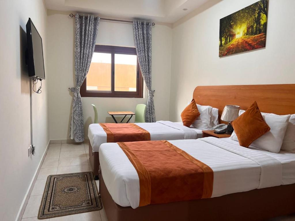 duas camas num quarto de hotel com televisão em Marhaba Deira Hotel em Dubai