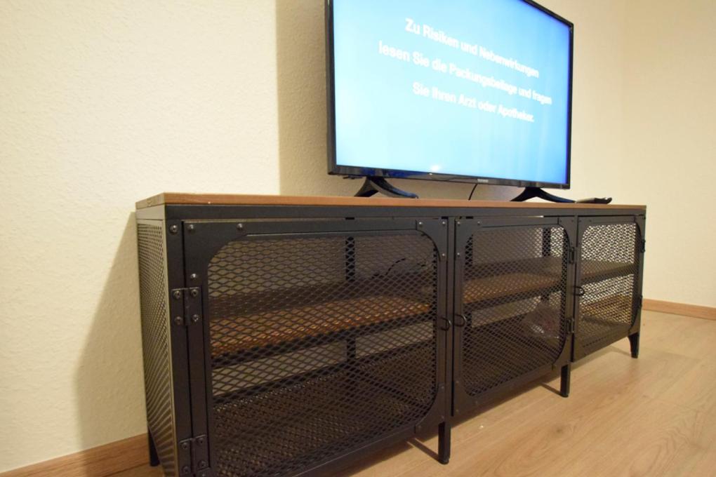 a television on top of a tv stand with a screen at Air Apartments 7 in Bremen