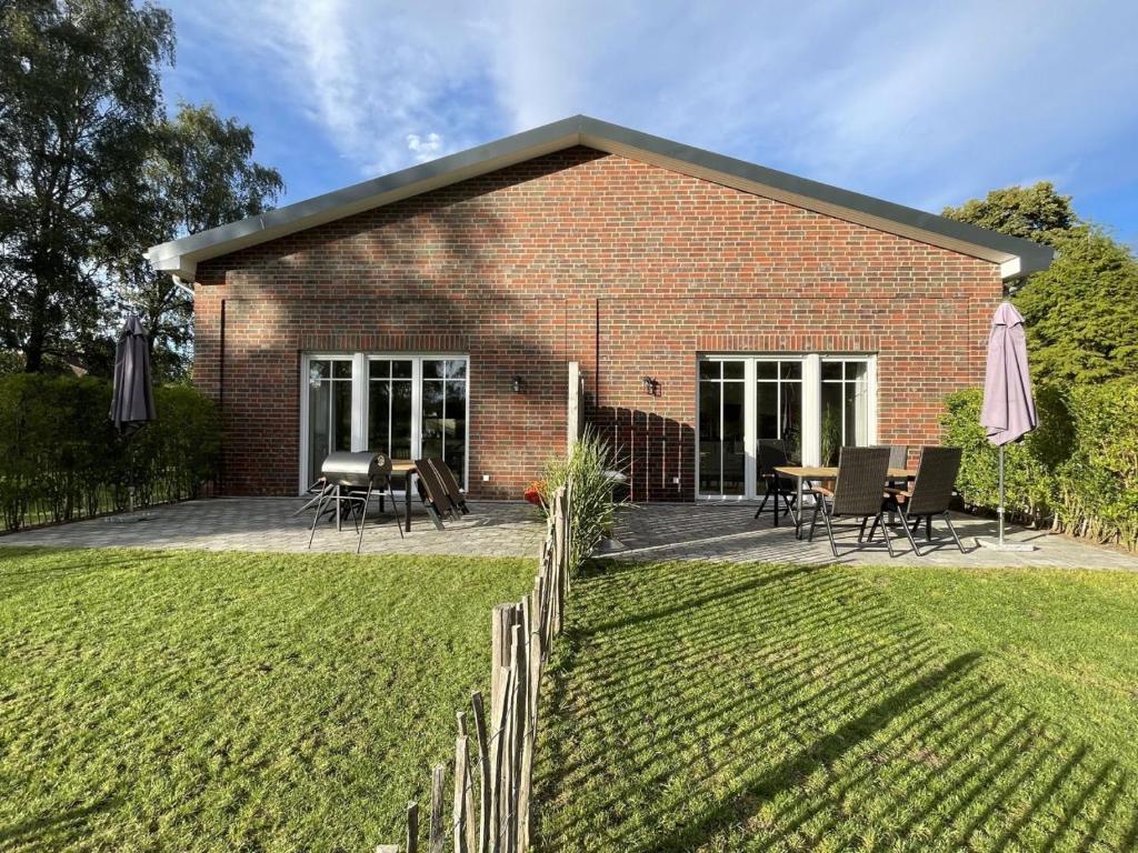 een bakstenen gebouw met een patio en een tafel en stoelen bij Ferienhof Timmerloher Heide in Soltau