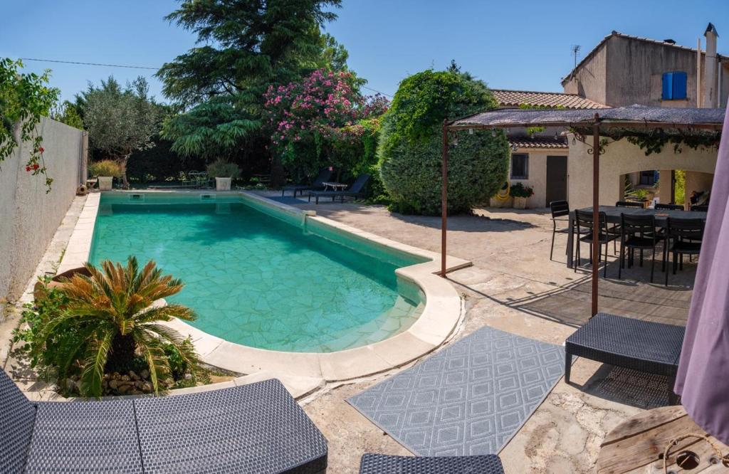 - une piscine dans une cour avec des chaises et une table dans l'établissement Maison provençale, à Pernes-les-Fontaines