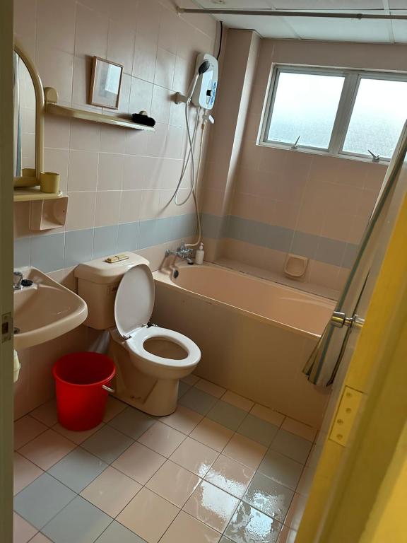 y baño con aseo, bañera y lavamanos. en Bukit Tinggi 1 Hati guesthouse en Bukit Tinggi
