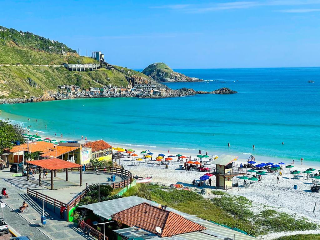 una spiaggia con ombrelloni e persone sulla spiaggia di Sophia I - Praia Grande ad Arraial do Cabo