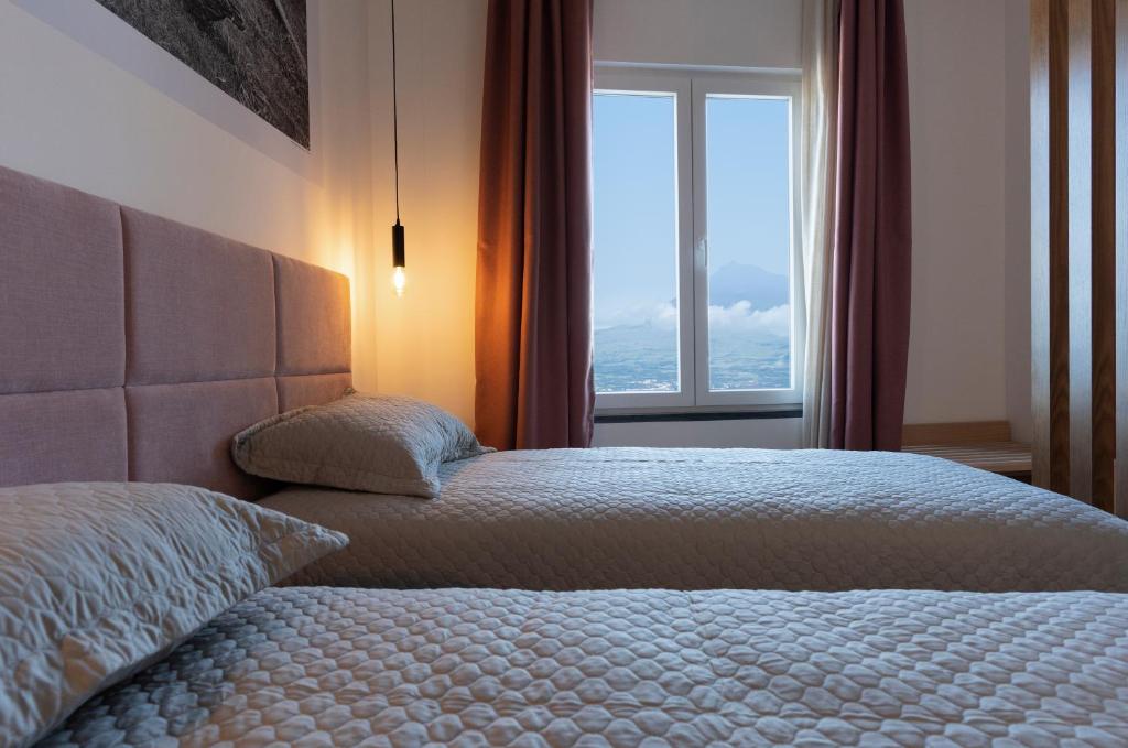 a bedroom with a bed and a large window at Horta Bay in Horta