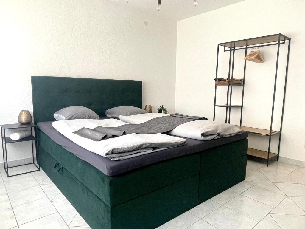 duże łóżko z zielonym zagłówkiem w pokoju w obiekcie Fewo Lago di Costanza 2 w mieście Friedrichshafen