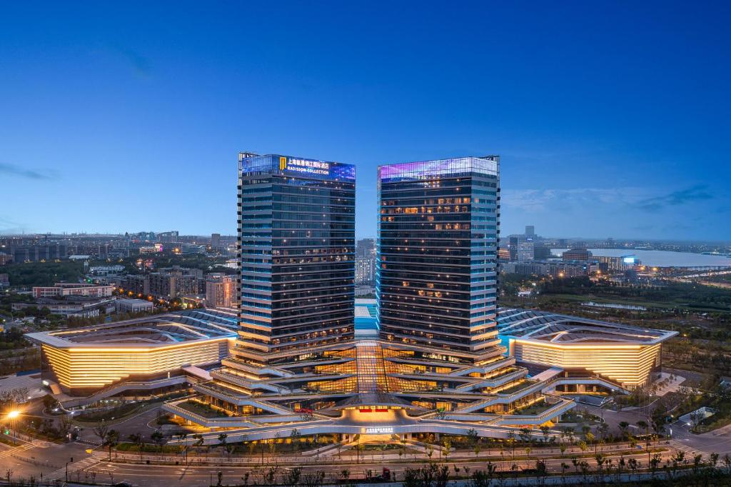 two tall buildings in a city at night at Radisson Collection Lingang Shanghai in Shanghai