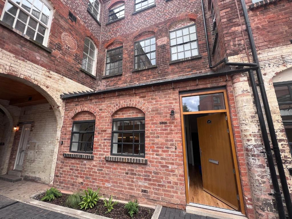 an old brick building with a brown door at Luxury Birmingham 2 Bedroom Town House in Birmingham